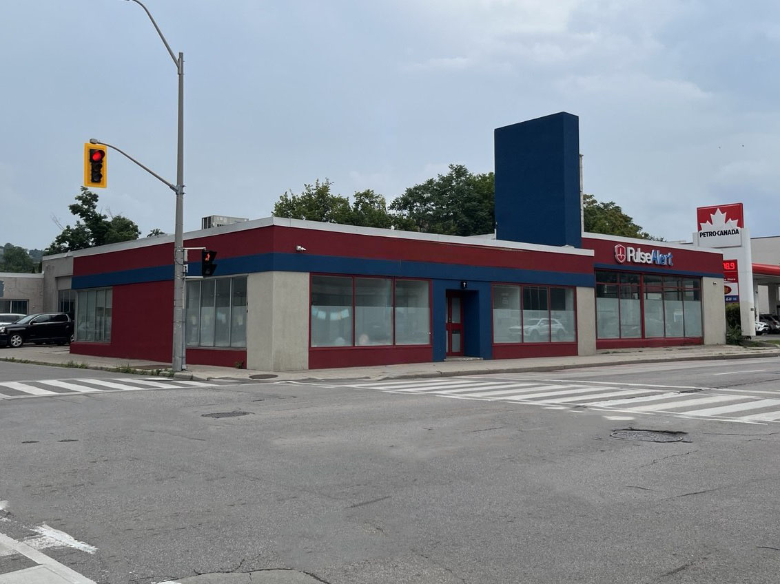 The Pulse Alert head office at 150 Main St E in Hamilton, Ontario &mdash; a red and blue storefront building on a street corner